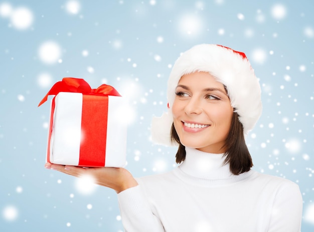 Navidad, Navidad, invierno, concepto de felicidad - mujer sonriente con sombrero de ayudante de santa con caja de regalo
