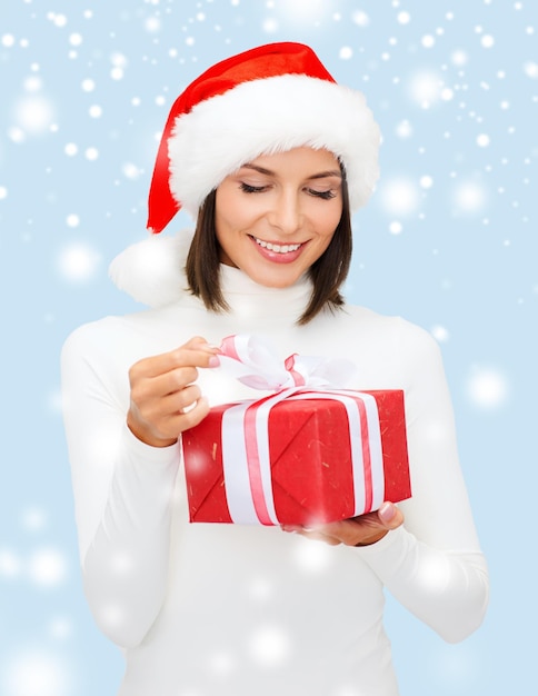 Navidad, Navidad, invierno, concepto de felicidad - mujer sonriente con sombrero de ayudante de santa con caja de regalo