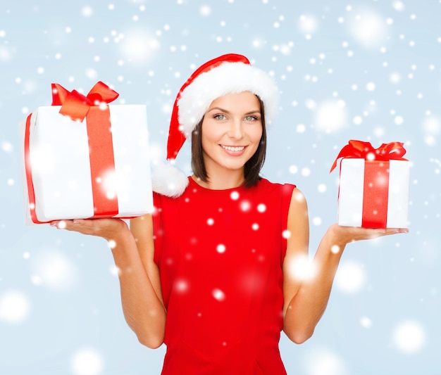 Navidad, Navidad, invierno, concepto de felicidad - mujer sonriente con sombrero de ayudante de santa con muchas cajas de regalo