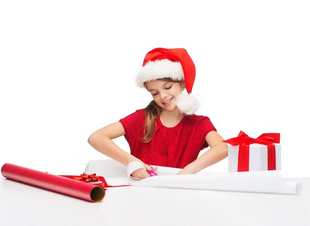 Navidad, Navidad, invierno, concepto de felicidad - niña sonriente con sombrero de ayudante de santa con caja de regalo