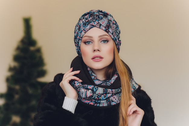 Navidad niña vistiendo gorro de punto y guantes, aislados en gris