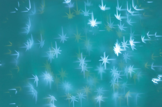 Navidad o Año Nuevo fondo de luz mágica abstracta estrellas blancas brillantes bokeh en verde acuamarina fon como telón de fondo de vacaciones de invierno Xmas estética foto efecto borrón celebración iluminación