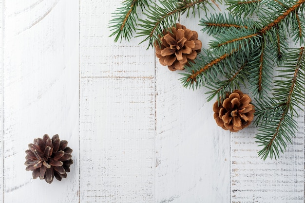 Navidad o año nuevo. Ramas de abeto, juguetes para árboles de Navidad, estrellas, copos de nieve y conos en madera blanca.