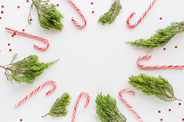 Navidad plana con bastones de caramelo y ramas de abeto