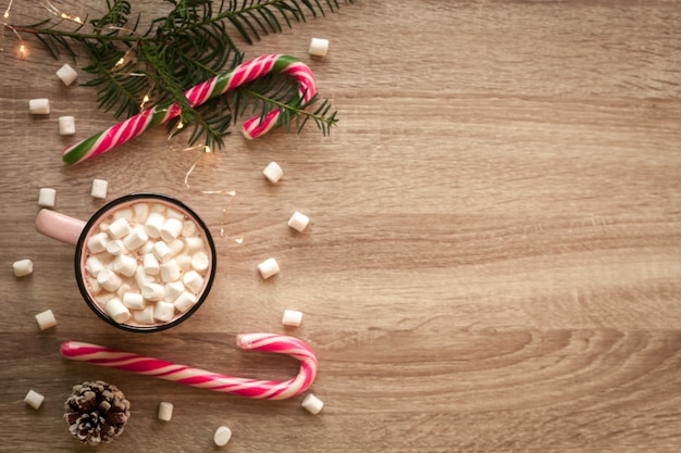 Navidad plana con taza de café rosa con malvaviscos y dulces