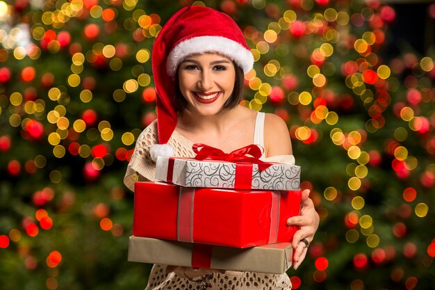 Navidad Santa sombrero aislado mujer retrato mantenga regalo de Navidad. Sonriente niña feliz sobre fondo de Navidad