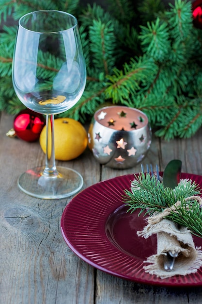 Navidad sirviendo de un vaso con un plato y una vela sobre la mesa.