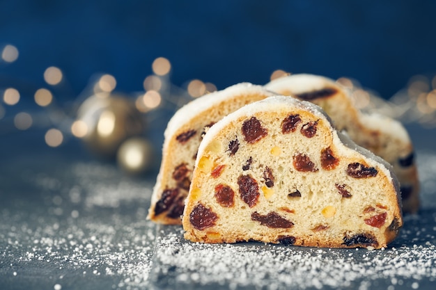 Navidad stollen en composición festiva azul oscuro con luces de Navidad