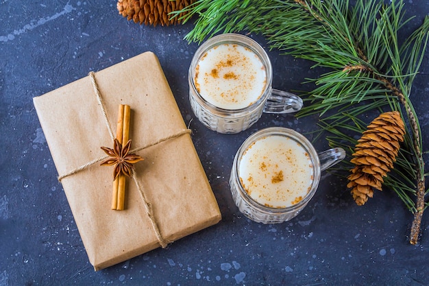 La Navidad tradicional estadounidense y kandaciana bebe ponche de huevo en vasos de cristal. Caja de regalo de año nuevo