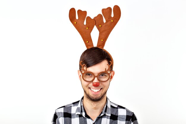 Foto navidad, vacaciones y concepto divertido - hombre con cuernos de ciervo y rudolf nous sobre fondo blanco.