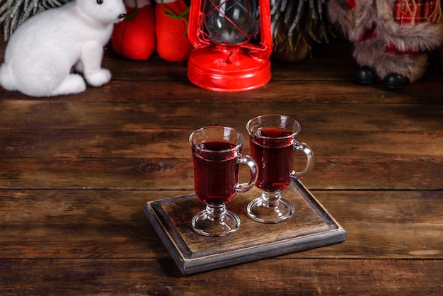 Navidad vino tinto caliente con especias y frutas sobre una mesa oscura.