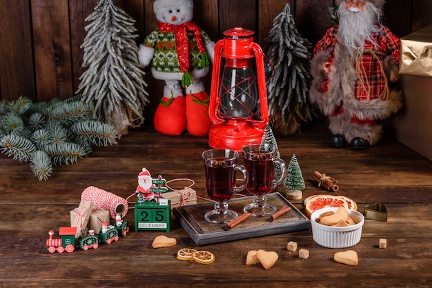 Navidad vino tinto caliente con especias y frutas sobre una mesa oscura.