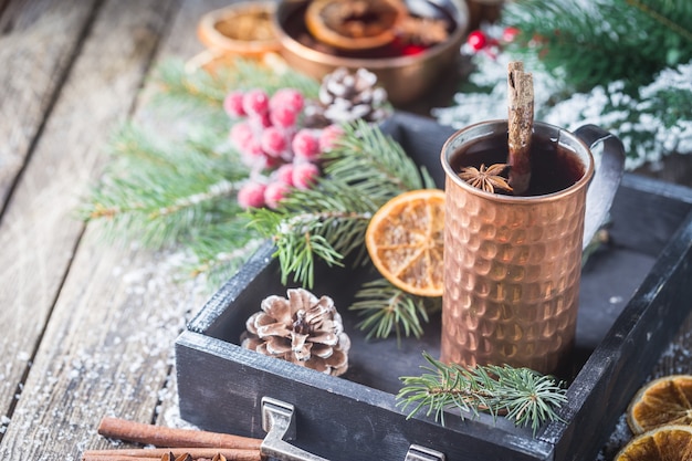 Navidad vino tinto caliente con especias y frutas sobre una mesa rústica de madera. Bebida caliente tradicional en Navidad