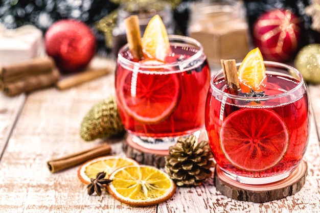 Navidad vino tinto caliente con especias y naranjas secas sobre una mesa de madera rústica. Bebida caliente tradicional para Navidad en los Estados Unidos