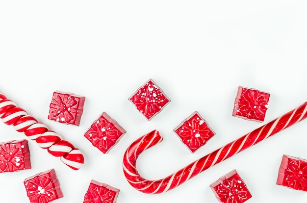 Foto navidad. vispera de año nuevo. fondo. caramelo rojo en forma de regalos sobre un fondo blanco.