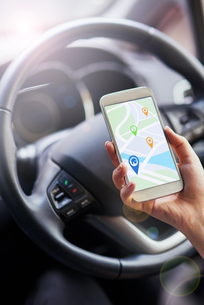 Navigation leicht gemacht Aufnahme einer Person in einem Auto, die ihr Telefon benutzt, um Wegbeschreibungen zu finden
