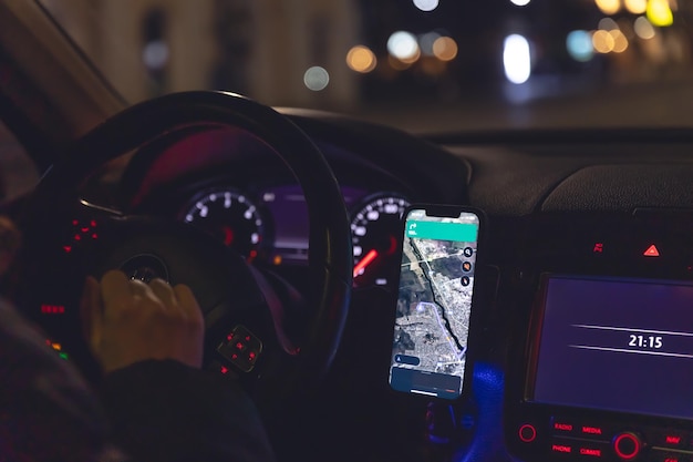 Navigator in einem Smartphone in einem Auto bei Nacht in Nahaufnahme