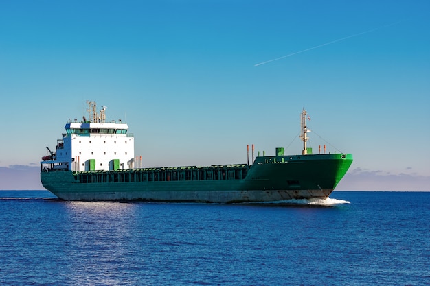 Navio de carga verde movendo-se nas águas paradas do mar báltico