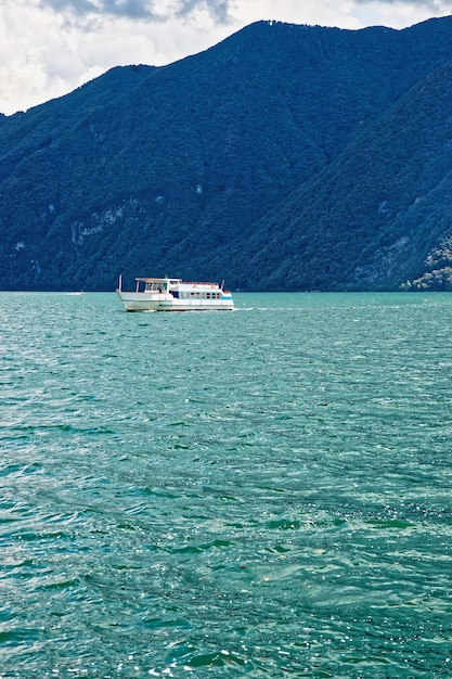 Navio de passageiros pequeno no passeio do resort luxuoso em Lugano nas montanhas do Lago Lugano e Alpes, cantão de Ticino, Suíça.