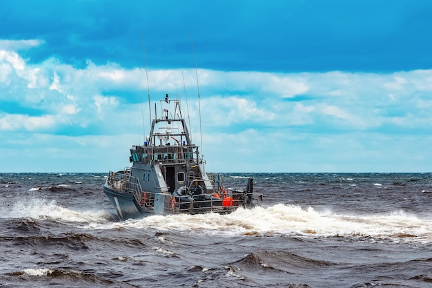 Navio militar cinzento navegando no mar báltico. serviço de guarda de fronteira