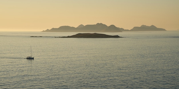 Navio solitário retornando ao pôr do sol ao porto de Baiona Pontevedra