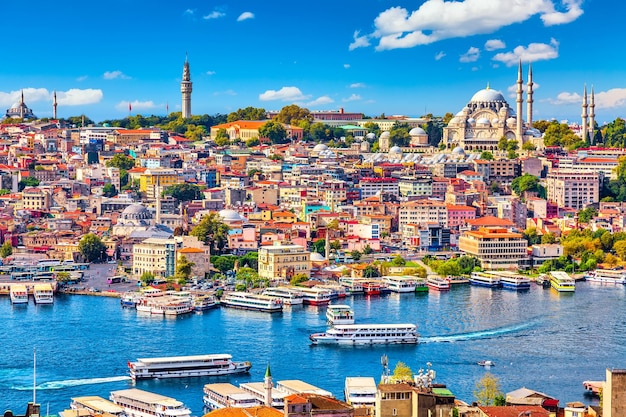 Navios turísticos na baía do Chifre de Ouro de Istambul e mesquita com o distrito de Sultanahmet contra o céu azul e nuvens. Istambul, Turquia, durante o dia ensolarado de verão.