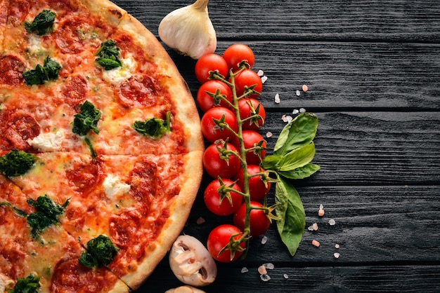 Foto neapolitanische pizza spinat-gorgonzola-käse-wurst-salami auf einem hölzernen hintergrund ansicht von oben