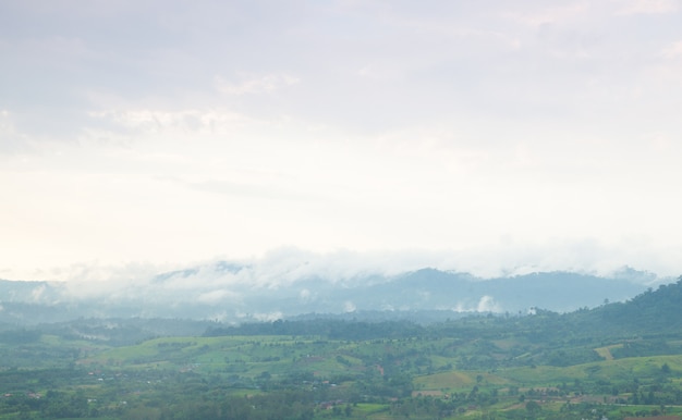 Nebel bedeckte Berge und Ackerland.