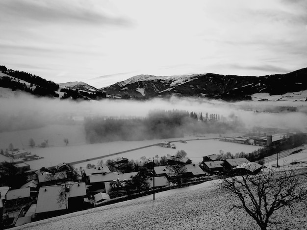 Nebel über schneebedecktem Dorf gegen den Himmel