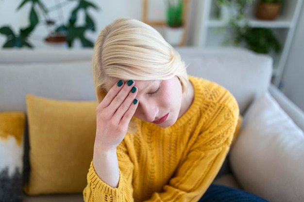 Nebenhöhlenschmerzen, die sehr schmerzhafte Kopfschmerzen verursachen. Ungesunde Frau mit Schmerzen. Scharfe starke Wunde. Sinusschmerzen, Sinusdruck, Sinusitis. Traurige Frau, die ihren Kopf wegen Nebenhöhlenschmerzen hält