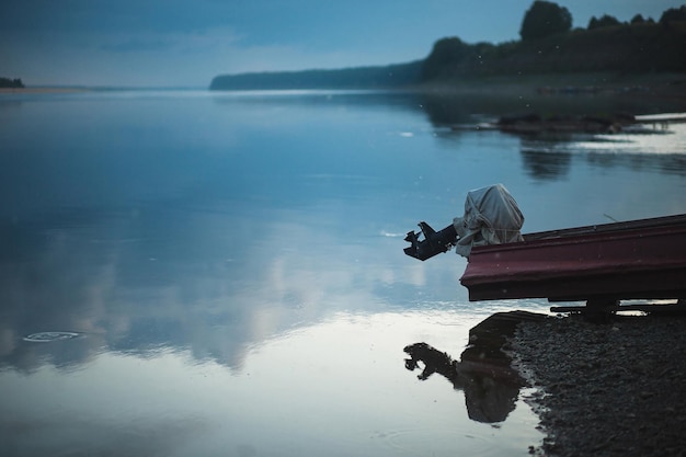 Neblige Nachtlandschaft mit Motorboot und Flusswasseroberfläche Nördliche Dwina Russland