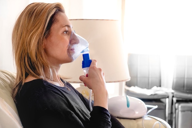 Foto nebulizador aerosol mujer inhalador máquina de medicina en el hogar