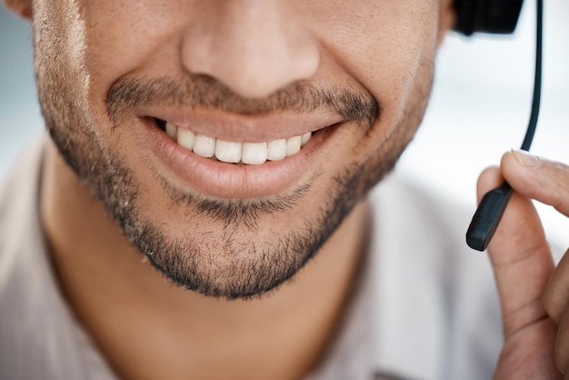 Se necesita coraje para crecer Fotografía de un hombre irreconocible sonriendo y trabajando con un auricular en el trabajo