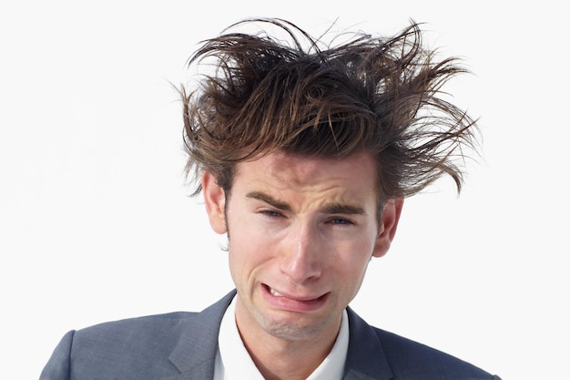 Necesito ayuda Un joven hombre de negocios con el pelo desordenado gimiendo mientras está aislado en blanco