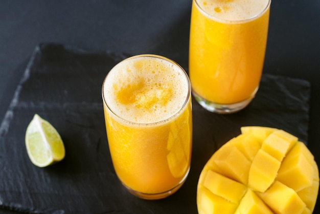 Néctar de suco de manga e limão Uma bebida refrescante de verão em um fundo preto Amarelo brilhante