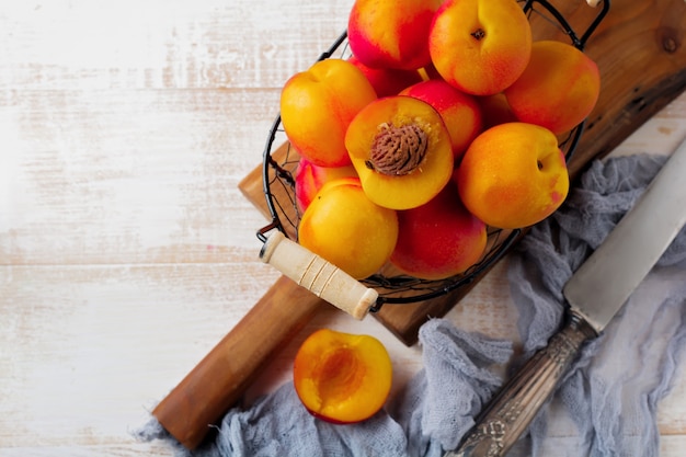 Nectarina de frutas suculentas frescas em grade de metal em madeira branca.