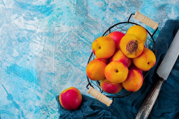 Foto nectarina de frutas suculentas frescas em grade de metal no concreto azul.