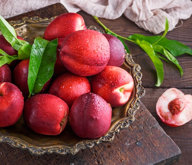 Nectarina roja de duraznos maduros en una placa de hierro