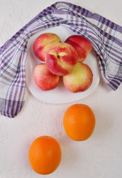 Nectarinas e laranjas em um prato de frutas frescas