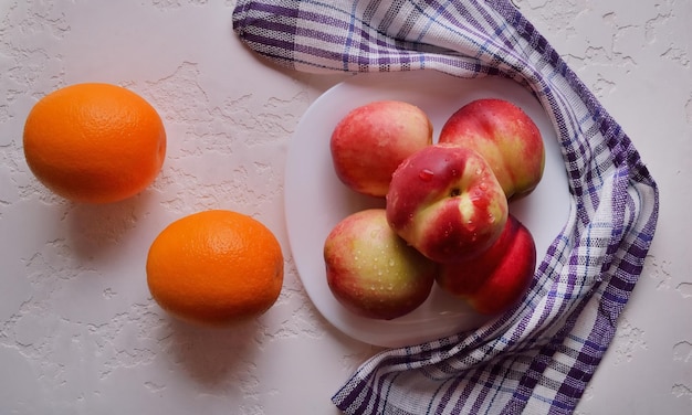 Nectarinas e laranjas em um prato de frutas frescas