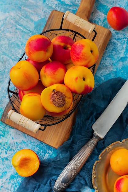 Nectarinas de frutas jugosas frescas en rejilla metálica sobre hormigón azul.