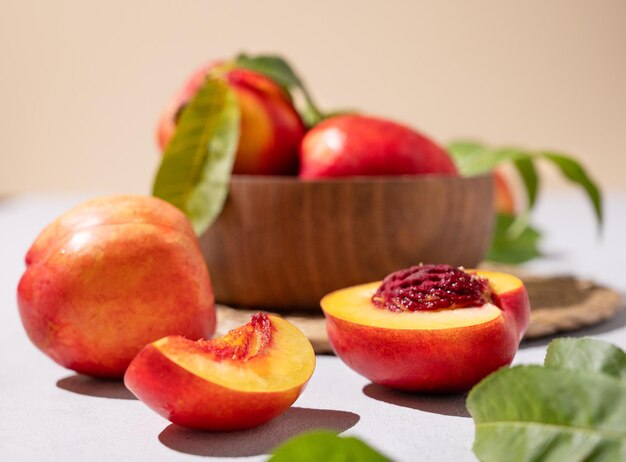 Nectarinas jugosas y dulces en un cuenco sobre un fondo claro de cerca Concepto de frutas de granja orgánicas saludables