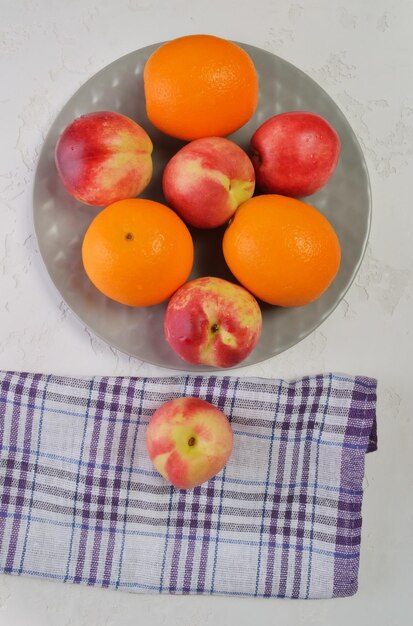 Nectarinas y naranjas en un plato de fruta fresca