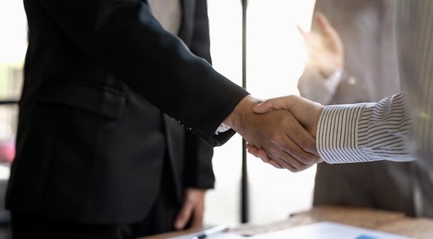 Negociación exitosa y concepto de apretón de manos dos hombres de negocios se dan la mano con un socio para celebrar una asociación y un acuerdo comercial de trabajo en equipo