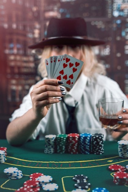 Negociadora estricta en las clásicas cartas de trato en la mesa de póquer, la crupier es una mujer