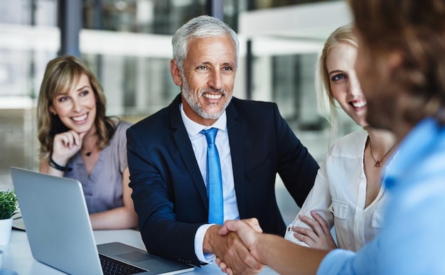 Negociando negócios como um chefe Foto de empresários apertando as mãos durante uma reunião no trabalho