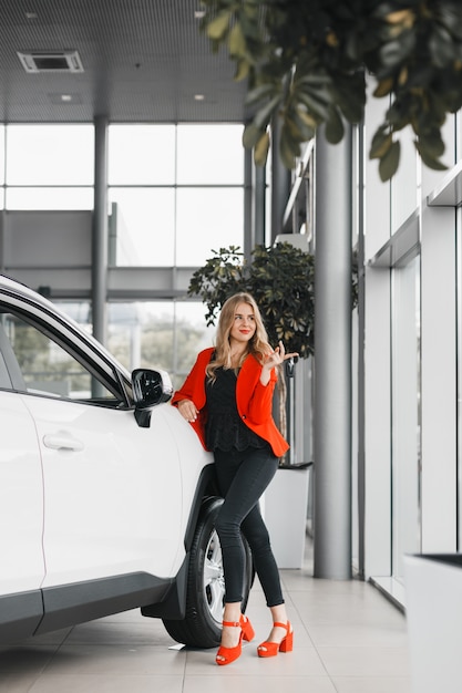 Negociante de carro que guarda uma chave e que olha para fora o carro branco seguinte completo estando.