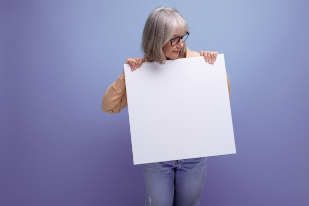 Negocio de abuela de mujer moderna con cabello gris sosteniendo papel con mocap en el fondo del estudio con