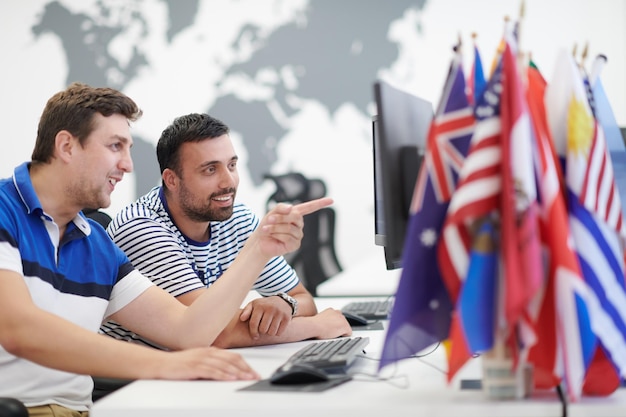 Foto negócio de inicialização, dois desenvolvedores de software masculinos trabalhando no computador no novo escritório de plano aberto moderno