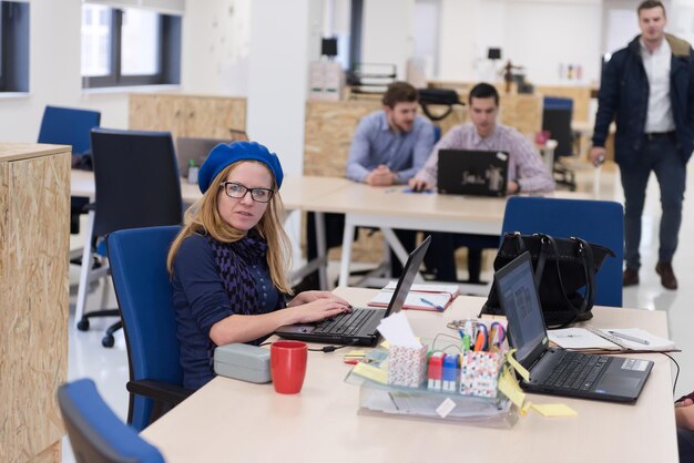 negócio de inicialização, mulher trabalhando no computador portátil no escritório moderno